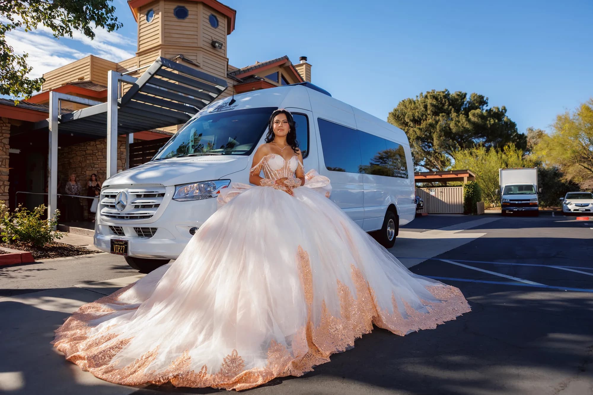 Isabella in her blush quinceañera gown beside a white vehicle in Old Town Temecula